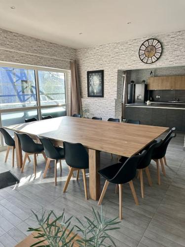 - une grande table et des chaises en bois dans la cuisine dans l'établissement Au coin de la rue, à Rhinau