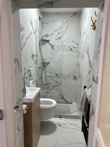 une salle de bain avec une douche, des toilettes et un lavabo dans l'établissement Au coin de la rue, à Rhinau