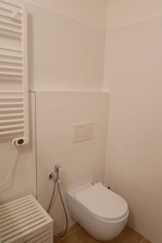 a white bathroom with a toilet and a sink at Casa Barcelli Sport & Family Apartments in Nago-Torbole