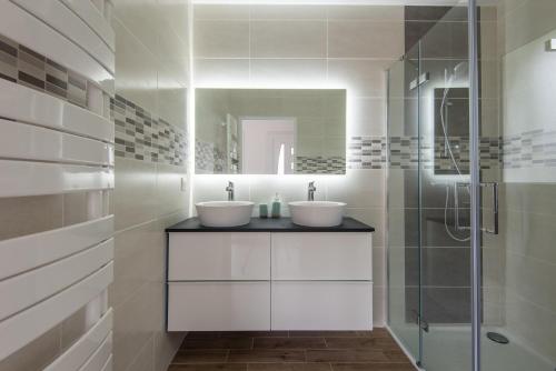 łazienka z 2 umywalkami i prysznicem w obiekcie Maison avec jacuzzi w mieście Biscarrosse