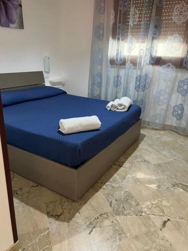 1 dormitorio con 1 cama con toallas en casa La Mimosa, en Castelluzzo