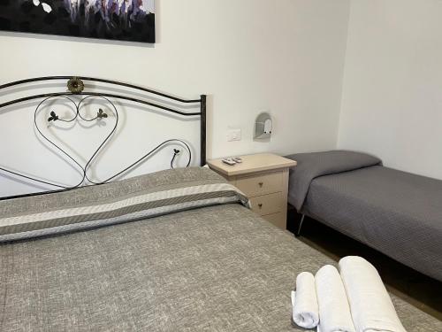 1 dormitorio con cama, mesita de noche y cama sidx sidx sidx sidx sidx en casa La Mimosa, en Castelluzzo