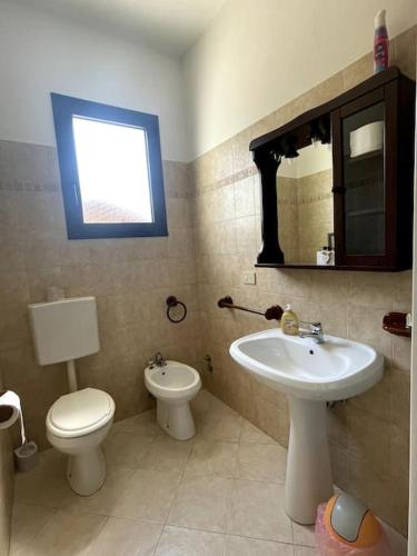 a bathroom with a sink and a toilet and a mirror at Bungalows Alloggi Angiolin Ketty in Cavallino-Treporti