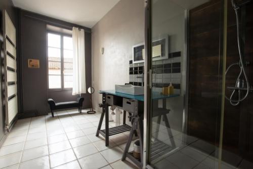 a bathroom with a shower and a desk in a room at Le Clos'art in Vinassan