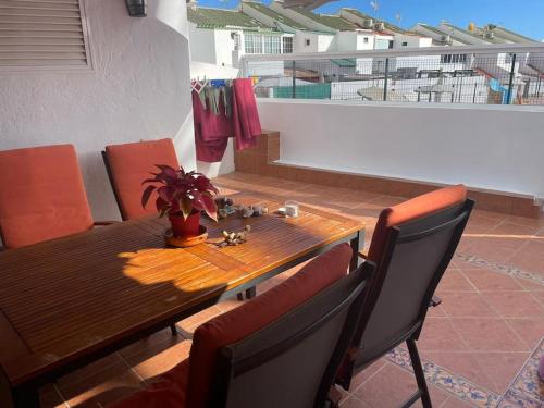 a dining room table and chairs with a table and a balcony at Entire townhouse in the paradise in Maspalomas