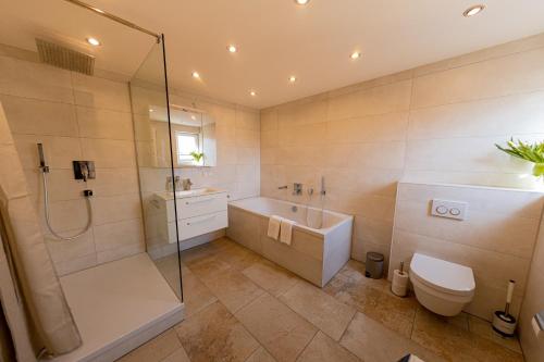 uma casa de banho com um chuveiro, uma banheira e um WC. em BONNYSTAY Landshut Monument em Landshut
