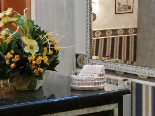 a table with a vase of flowers and a mirror at Hotel Teti in Rome