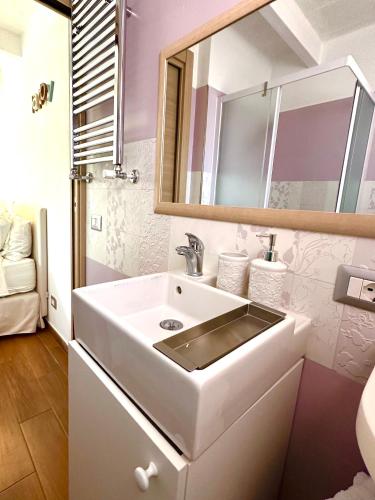 a bathroom with a white sink and a mirror at La Casa in Bari