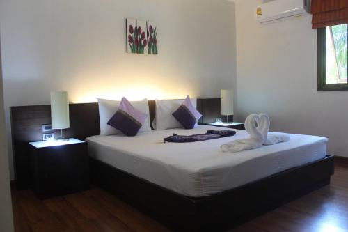 1 dormitorio con 1 cama grande y 2 mesitas de noche en Palm Inn, en Ban Na Phong