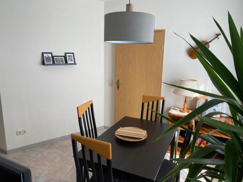 a dining room with a black table and chairs at FeWo Roland Ranft direkt am Kurpark Barrierearm 60qm in Bad Elster
