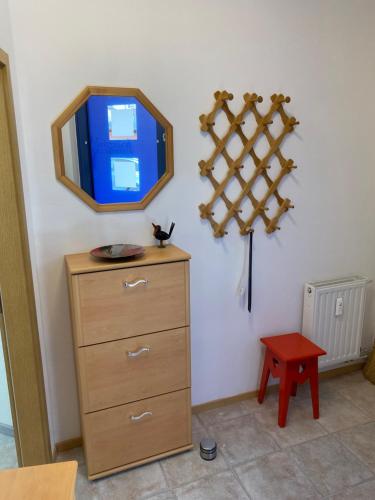 a tv on a wall with a dresser and a table at FeWo Roland Ranft direkt am Kurpark Barrierearm 60qm in Bad Elster