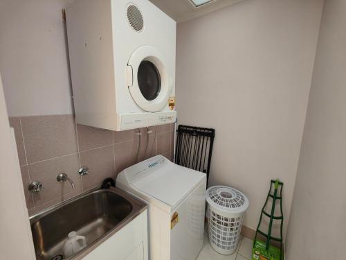 Il comprend une petite cuisine avec un évier et un lave-linge. dans l'établissement Tuggeranong Short Stay #08 - Sleeps 6, à Tuggeranong