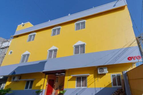 KālapettaiにあるGnanam Beach Residencyの白窓のある黄色い建物