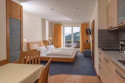 シュラートミンクにあるAparthotel Tritscherのベッドルーム1室(ベッド1台付)、キッチン(テーブル付)
