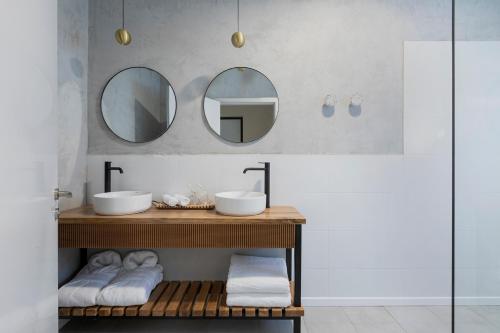 a bathroom with two sinks and two mirrors at Sera Suites in Merhavyāh
