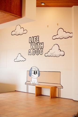 a wall mural with a dog in a room with a bench at Doggy's Izujogasaki in Ito