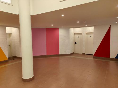 a large room with red and white walls and columns at Tuggeranong Short Stay #08 - Sleeps 6 in Tuggeranong