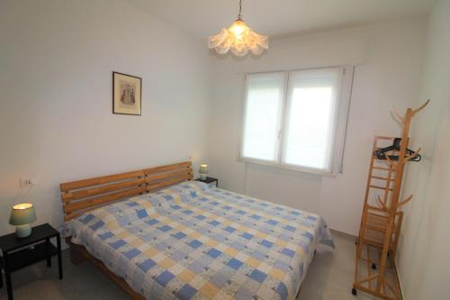 1 dormitorio con cama, escalera y ventana en Villa Patrizia, en Lignano Sabbiadoro