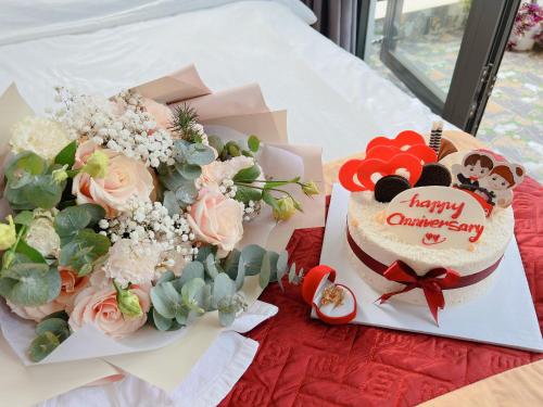 a birthday cake and flowers on a table at Ánh Vân Villa hotel in Da Lat