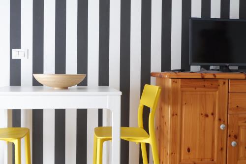 a dining room with a table and yellow chairs at Casa Barcelli Sport & Family Apartments in Nago-Torbole