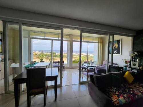 un salon avec un canapé et une table avec vue dans l'établissement Melrose Beach - Apartment with a beach view, à Dar Bouazza