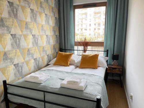 a bedroom with a bed with two towels on it at Apartament Starowiejska 54 in Gdańsk