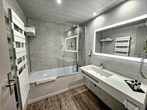 a bathroom with a sink and a tub and a mirror at Domaine de la Forêt d'Orient, Logis Hôtel, Restaurant, Spa et Golf in Rouilly-Sacey