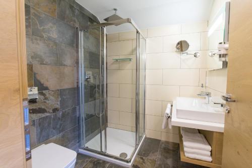 a bathroom with a shower and a sink at AIGO Welcome Family Resort in Aigen im Mühlkreis