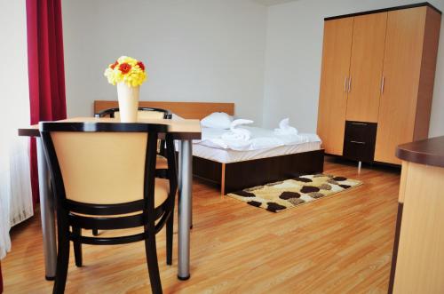 a room with a table with a vase of flowers on it at ApartHotel Zorilor in Cluj-Napoca