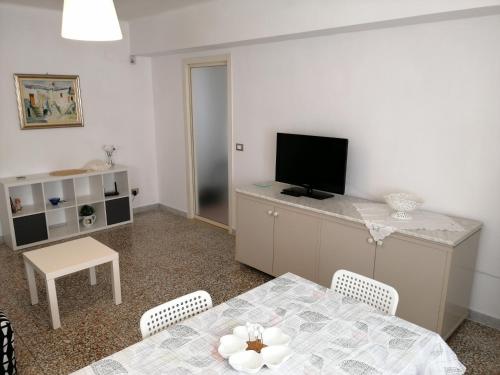 uma sala de estar com uma mesa e uma televisão em CASA MINU' - Affitti Brevi Italia em Bari