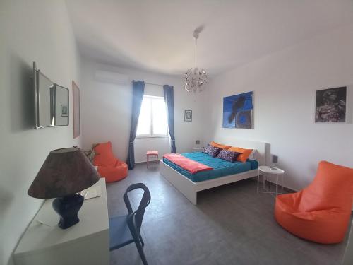 - une chambre avec un lit, un canapé et une chaise dans l'établissement Lo scorcio della Neapolis Accogliente appartamento pressi parco Neapolis, à Syracuse
