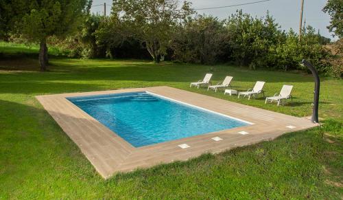 a swimming pool with lounge chairs in a field at Casa Rural en Rupià con piscina in Rupiá