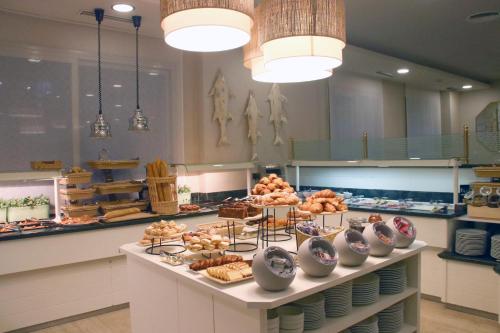 a bakery with a variety of pastries on a counter at Hotel Miramar in Lloret de Mar