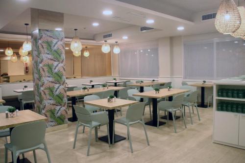 a restaurant with tables and chairs in a room at Hotel Miramar in Lloret de Mar