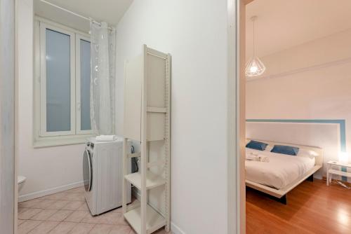 a bedroom with a bed and a room with a refrigerator at Mazzini 12, Elegant Central Apartment, Air Conditioning, Wi-Fi, Just 100 mt from the Public Beach, the Ideal Choice for a Relaxing and Exciting Coastal Escape, private garage available on request at 20,00 per night in Rapallo