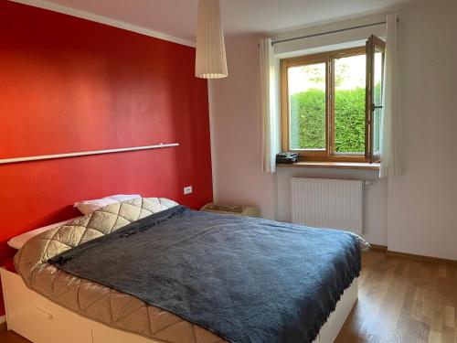 um quarto com uma cama com uma parede vermelha em Casa dei sogni em Valdaora
