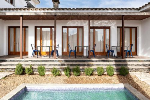 a patio with chairs and tables and a swimming pool at Casa Maui in Banyoles