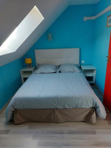 ein blaues Schlafzimmer mit einem Bett mit blauer Wand in der Unterkunft le four à pain in Faverolles