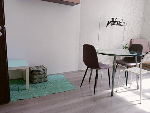 une salle à manger avec une table et des chaises en verre dans l'établissement Apartmán Hybešova, à Brno