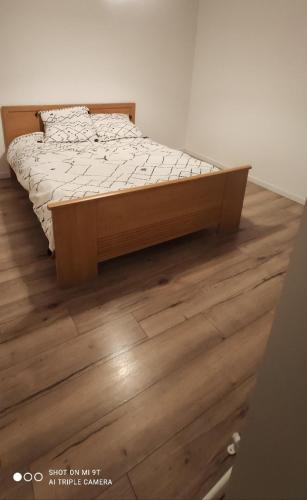 Ce lit se trouve dans une chambre dotée de parquet. dans l'établissement Appartement 4 personnes, garage privé, balcon, à Saint-Étienne