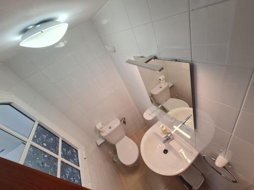 uma casa de banho com um lavatório, um WC e um espelho. em We Fuerteventura em Caleta de Fuste