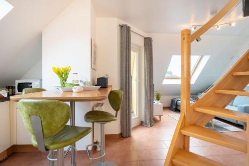 cocina con mesa y sillas verdes en una habitación en Strandpark-Grossenbrode-Haus-Meerblick-Wohnung-16, en Großenbrode