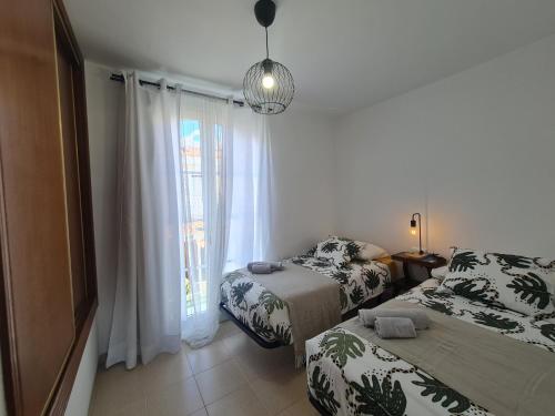 a bedroom with two beds and a window at We Fuerteventura in Caleta De Fuste