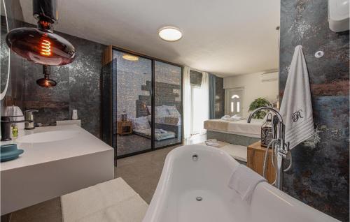 uma casa de banho com uma banheira, um lavatório e uma cama em 3 Bedroom Nice Home In Sevid em Sevid