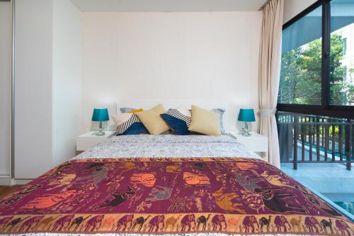 The Title Rawai West Wing Pool View Suite في شاطئ راوايْ: غرفة نوم بسرير كبير ونافذة