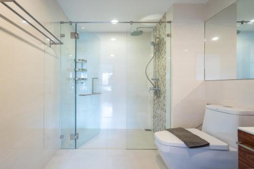 a bathroom with a glass shower and a toilet at The Title Rawai West Wing Pool View Suite in Rawai Beach