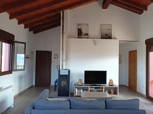a living room with a blue couch and a tv at La Casa de Nuria in Cangas de Onís