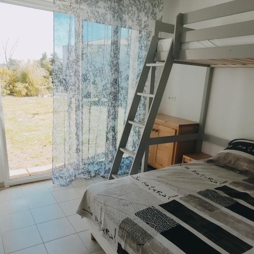 une chambre avec un lit superposé et une échelle dans l'établissement maison, mer, piscine, parking, à Poggio-Mezzana