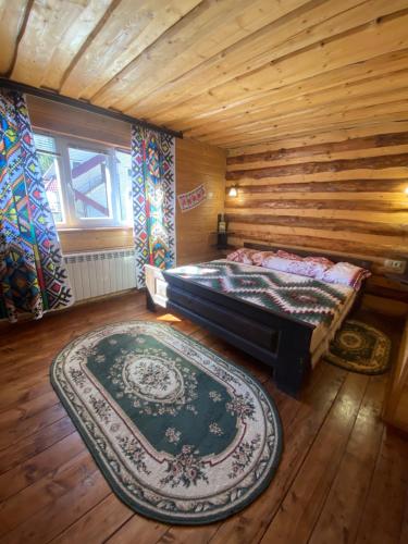 1 dormitorio con cama y alfombra grande en Сімейний номер 2 Садиба У Ані en Synevyrsʼka Polyana