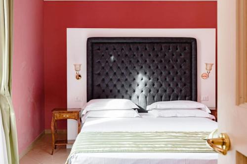 een slaapkamer met een groot bed met rode muren bij 41 NAZIONALE SUITE 41 in Rome